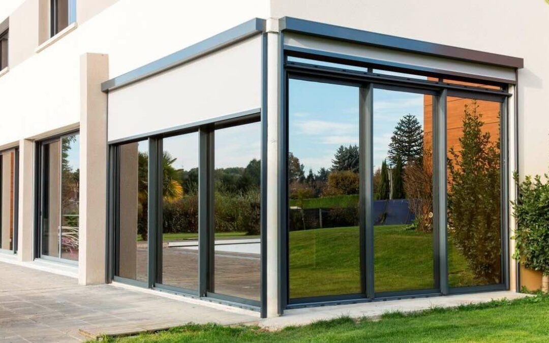 Extension vitree de maison traitee au film solaire, vue du jardin